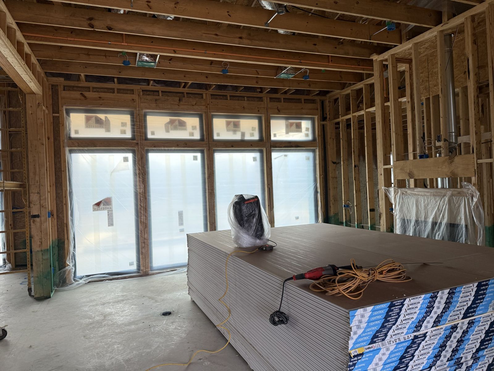 Framed great room with ductwork, gas line and electrical rough-in before drywall