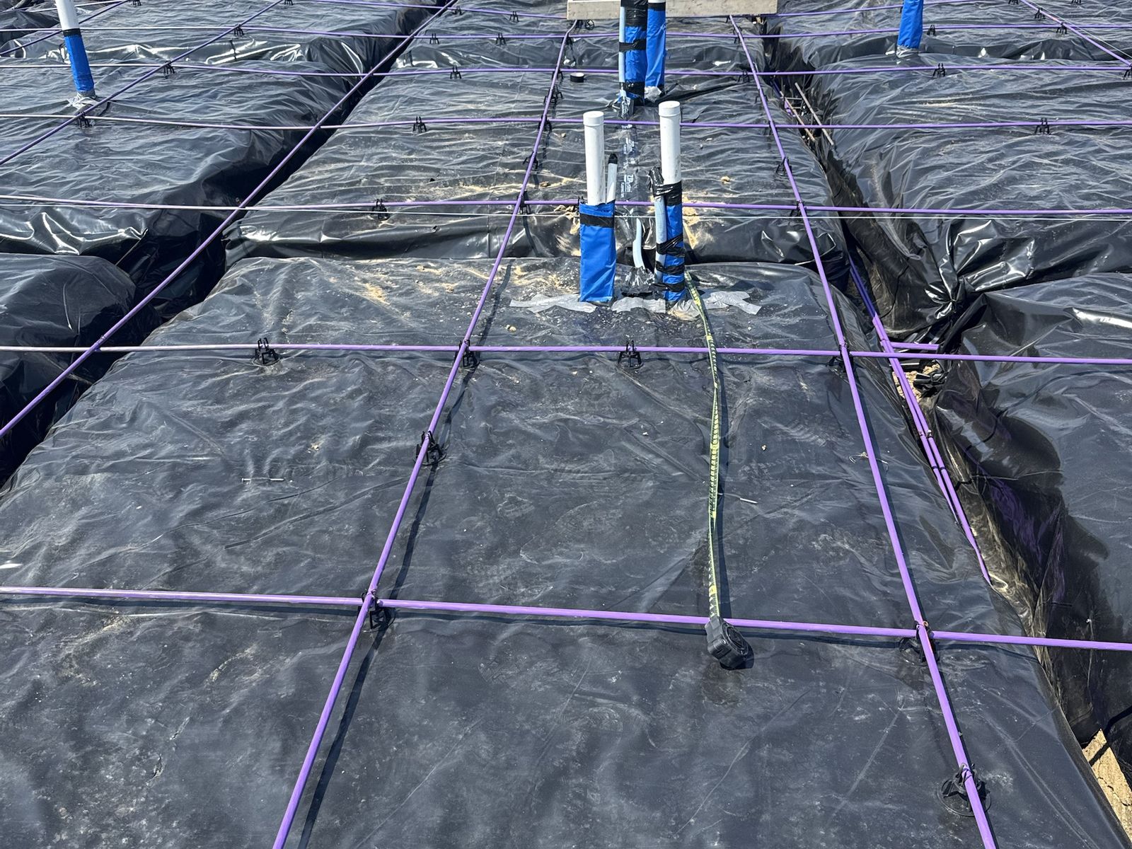 Post-tension cables on chairs over the vapor barrier before a slab pour